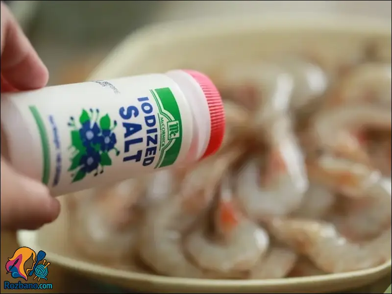 تمیز کردن میگو و ریختن نمک روی آن