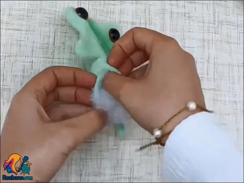 پر کردن داخل عروسک قورباغه با الیاف نرم